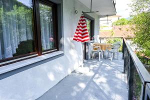 a porch with a umbrella on the side of a house at Apartman Nina in Jajce