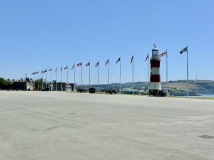 a lighthouse with a row of flags in front of it at Eden on the Hoe in Plymouth