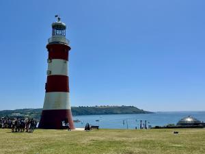 a red and white lighthouse sitting on top of a grass field at Eden on the Hoe in Plymouth