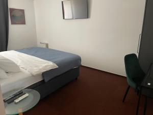 a bedroom with a bed and a table and a chair at hotel Diana in Murska Sobota