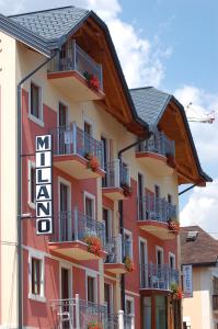 a large building with balconies and flowers on it at Hotel Milano in Asiago