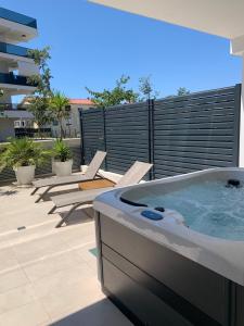 einen Whirlpool auf einer Terrasse mit Stühlen in der Unterkunft Capitol Suites Exclusive in Zadar