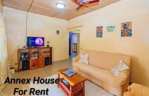 a living room with a couch and a tv at Annex House 2 in Manjai Kunda