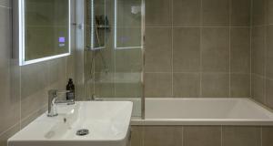 a bathroom with a sink and a shower and a tub at Best Western Hotel de Havelet in St. Peter Port +90 photos