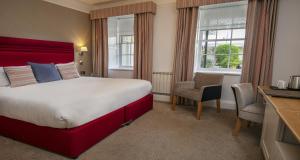 a hotel room with a large bed and a desk at Best Western Hotel de Havelet in St. Peter Port