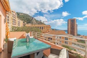 een balkon met een tafel en uitzicht op de stad bij Stunning Renovated 1-Bedroom Breathtaking View in Beausoleil