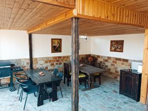 a dining room with wooden tables and chairs at Боровата къща in Varna City