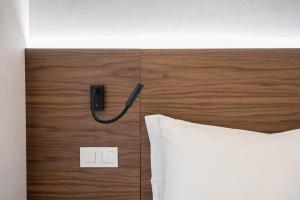 Una cabecera con un teléfono al lado de una cama. en GuestReady - Stylish base steps from attractions, en Oporto