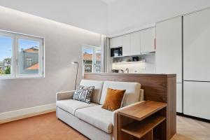 Una sala de estar con un sofá y una cocina. en GuestReady - Stylish base steps from attractions, en Oporto