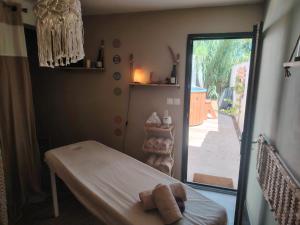 ピオランにあるSuite romantique avec jacuzzi privatifのベッド1台とガラスのスライドドアが備わる客室です。