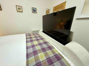 a bed with a fireplace in a room at Carron Cottage in Inverness