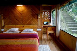 a bedroom with a bed in a wooden house at Dug Dug Camps, Bhimtal in Bhīm Tāl +70 photos