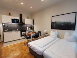 a bedroom with a white bed and a kitchen at Wien West Home in Vienna