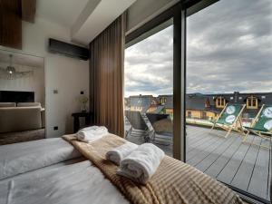 1 dormitorio con cama y vistas a la terraza en Miral Apartament nad Jeziorem Czorsztyńskim, en Kluszkowce
