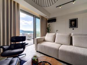 una sala de estar con un sofá y una silla en Miral Apartament nad Jeziorem Czorsztyńskim, en Kluszkowce