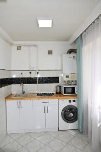 a kitchen with white cabinets and a washing machine at Your lovely stay in Yerevan, Komitas 30 in Yerevan +12 photos