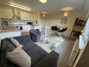 a living room with a couch and a kitchen at AmberBlue@Epsom in Epsom