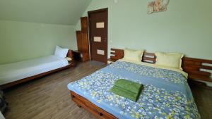 a bedroom with two beds and a green towel on the bed at Casa Maya in Săsciori +78 photos