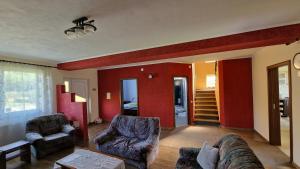 a living room with two couches and red walls at Casa Maya in Săsciori
