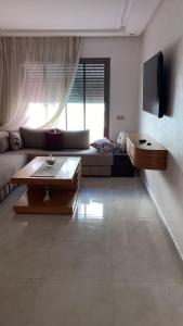 a living room with a couch and a table at Two bedroom Apartment in Bouznika Beach in Bouznika
