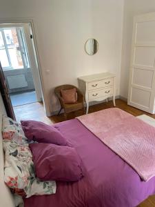 a bedroom with a bed with purple sheets and a dresser at Iago city,appartement spacieux 2 chambres, hyper centre, aéroport et gare à proximité in Beauvais