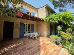 eine Terrasse mit Tisch und Stühlen vor einem Haus in der Unterkunft La Provençale - Piscine - Chambres climatisées in Aubignan