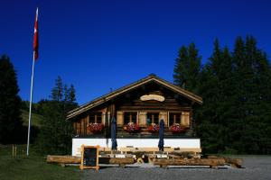 a building with a flag in front of it at Hotel Prätschli in Arosa