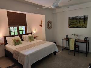 a bedroom with a bed and a table and a clock at Villa Lyvie ayurvedic hotel in Tangalle +63 photos