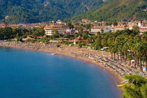 a beach with chairs and umbrellas in the water at Yade Luxe Hotel in Marmaris