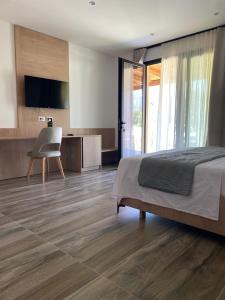 una camera da letto con un letto, una scrivania e una televisione di Nettuno Resort Orikum a Orikum