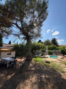 una mesa de picnic y un árbol en un patio en villa magui, en Aix-en-Provence