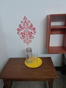 a table with a glass of water and a yellow plate at VR Jardin Resort in Pondicherry