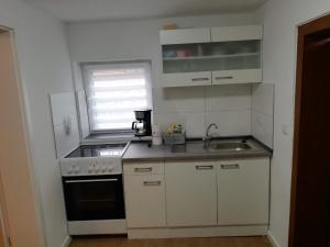 a small kitchen with a sink and a stove at Ferienwohnung am Halbmond in Badbergen +9 photos