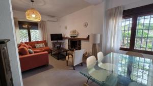 a living room with a glass table and a couch at Villa Los Gemelos in Calpe