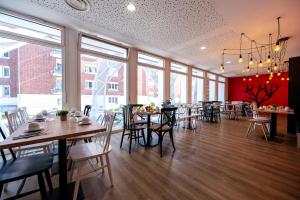 a restaurant with tables and chairs and large windows at Nemea Appart Hotel Coliseum Amiens Centre in Amiens