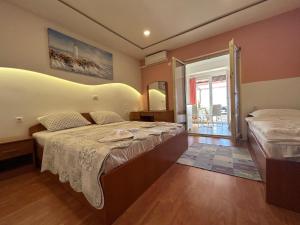 a bedroom with two beds and a large window at Apartments Kurilj in Makarska