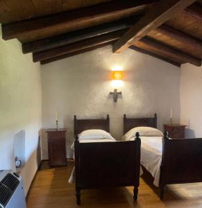 a bedroom with two beds and a light on the wall at La Torre della Casaforte Bergum alle porte di Cividale del Friuli in Cividale del Friuli