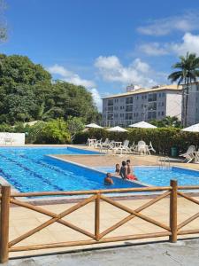 a group of people sitting in a swimming pool at Residencial MW Novo in Camaçari