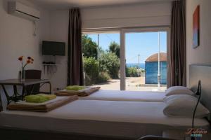 a bedroom with a large bed with a large window at Dubrava Rooms in Dobra Voda