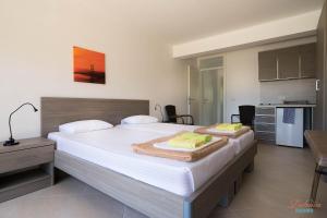 a bedroom with a large bed and a kitchen at Dubrava Rooms in Dobra Voda