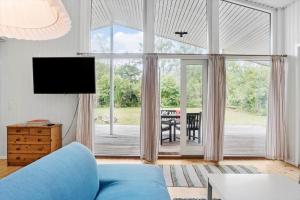 a living room with a blue couch and a large window at 4317-Stege-Oddermosevej-6 in Stege