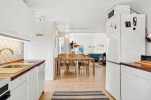 a kitchen with a white refrigerator and a dining room at 4317-Stege-Oddermosevej-6 in Stege +15 photos