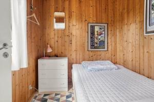 a bedroom with a bed and a wooden wall at 4317-Stege-Oddermosevej-6 in Stege