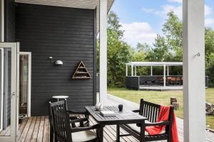 a patio with a table and chairs on a deck at 4317-Stege-Oddermosevej-6 in Stege