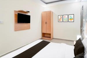 a bedroom with a bed and a tv on a wall at Hotel Elite rooms & Banquet in Prayagraj