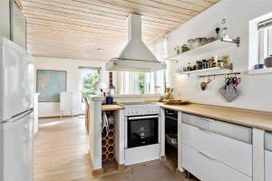 a kitchen with a white stove and a refrigerator at R744-Rodvig-Poppelager-7 in Rødvig