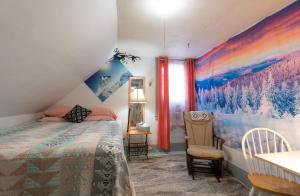 a bedroom with a bed and a table with a chair at Dancing Light Farm in Bridgton