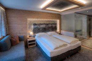 a bedroom with a large bed and a couch at Hotel Gramaser in Ischgl +91 photos
