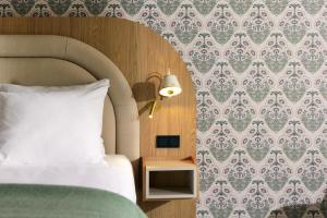 福伦丹Van der Valk Hotel Volendam - Recently renovated的卧室里有一张床和一张带灯的桌子