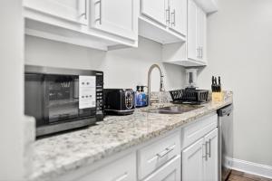 een witte keuken met een magnetron en een spoelbak bij Styling Gem 5mins to Downtown pool-gym-parking in Durham +4 foto's